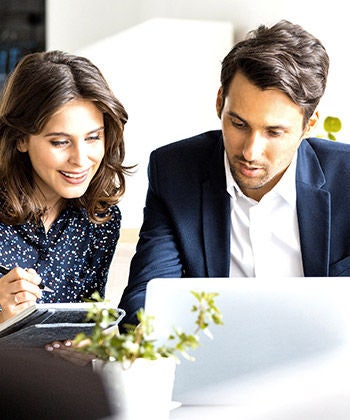 two colleagues looking at a laptop