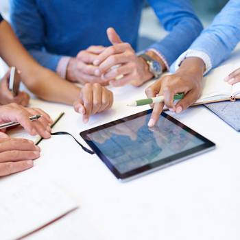 Yayınlar close up of people around a tablet