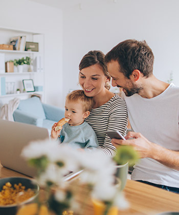 family at home in front of a laptop