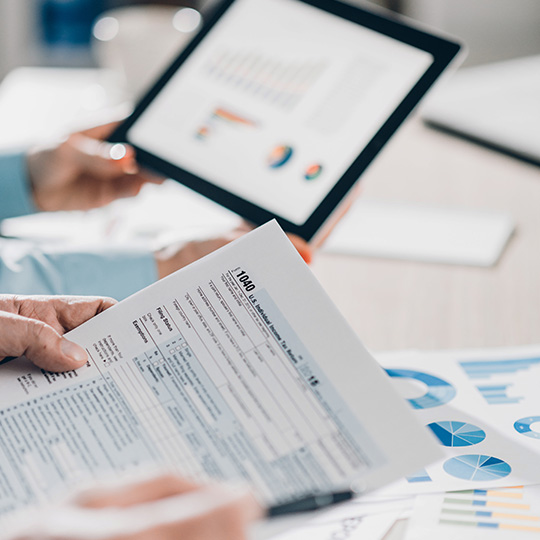 close up of tablet and graphs in a meeting